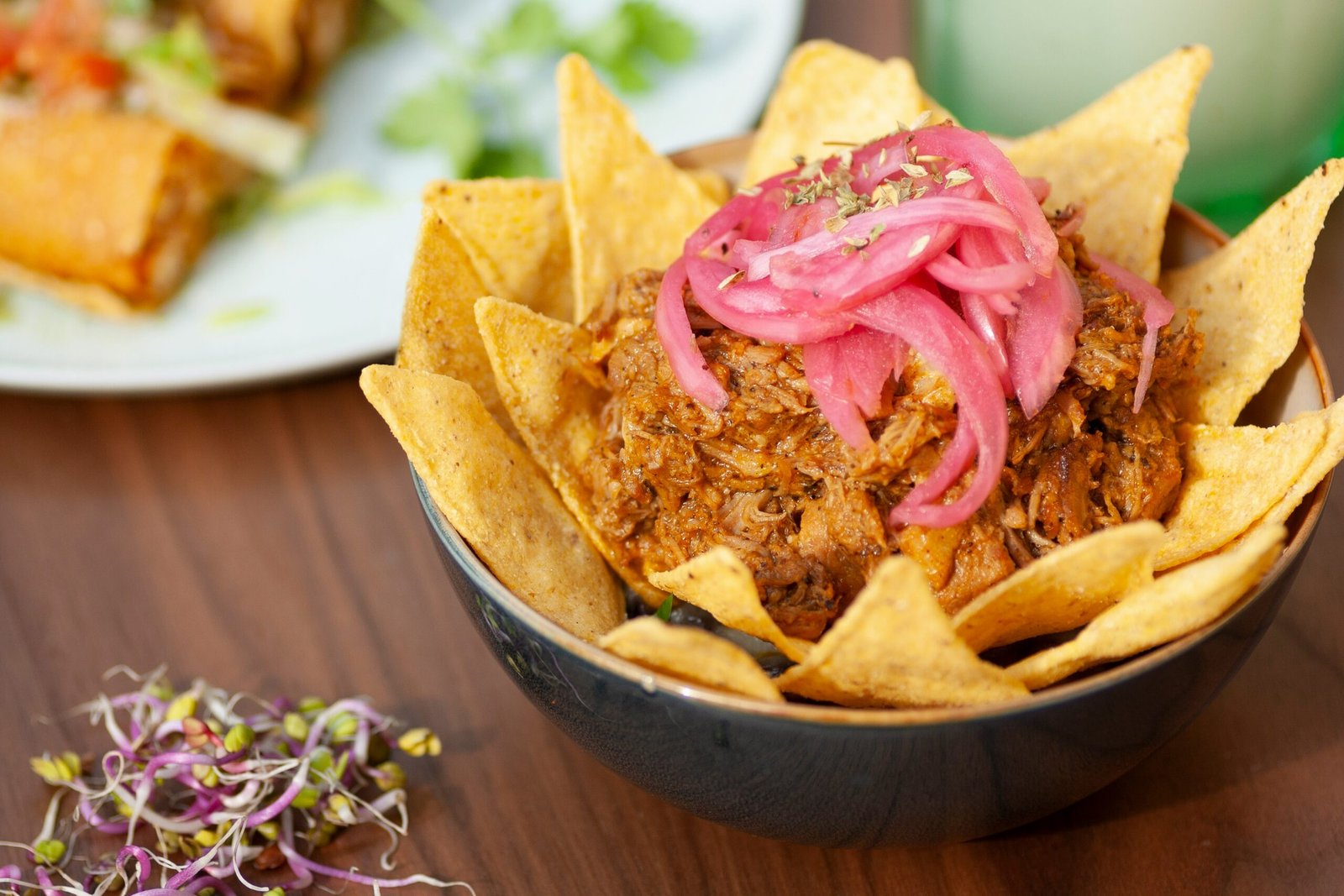 Cochinita served with tortilla chips and pickled red onion