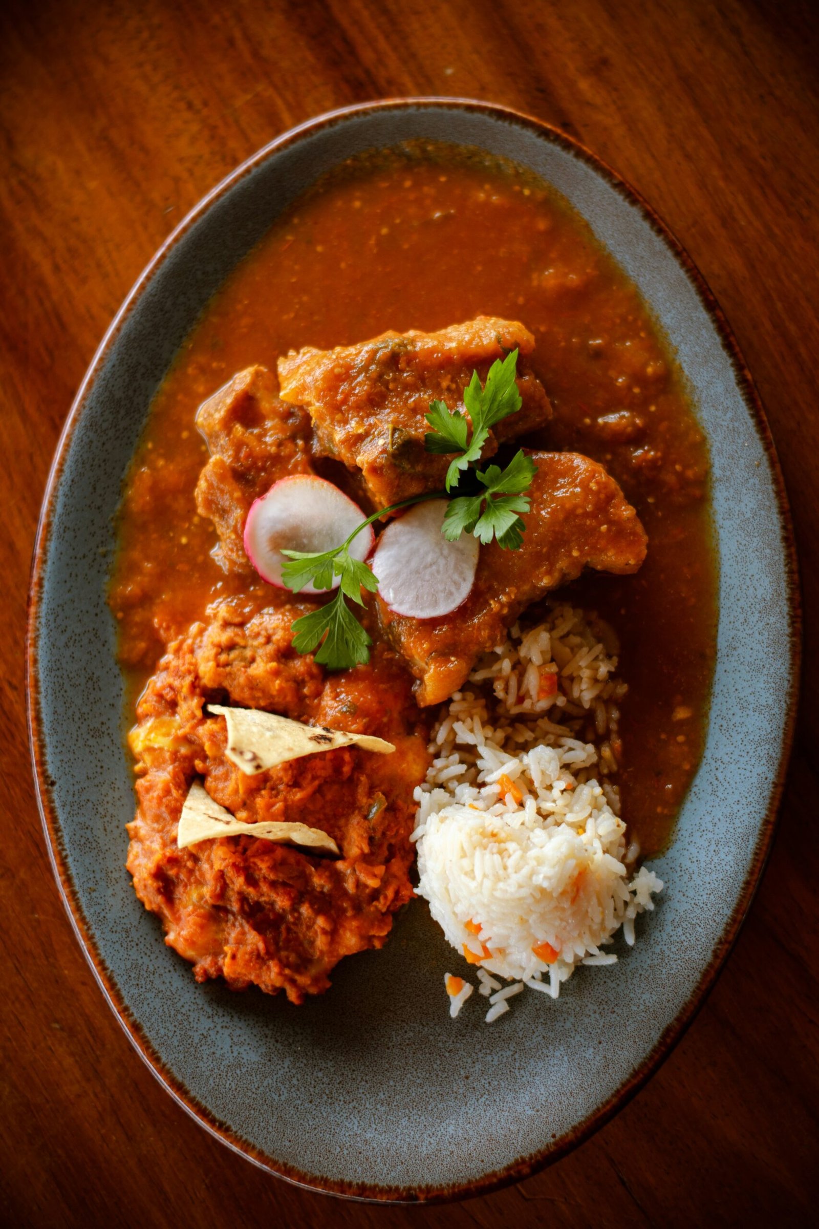 Meat covered in reddish mole sauce and served with rice